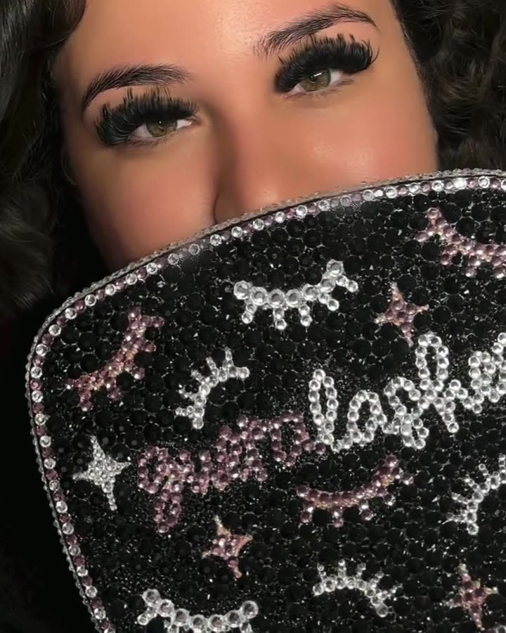 A client hides behind the rhinestone gueralashes bag after her lash set