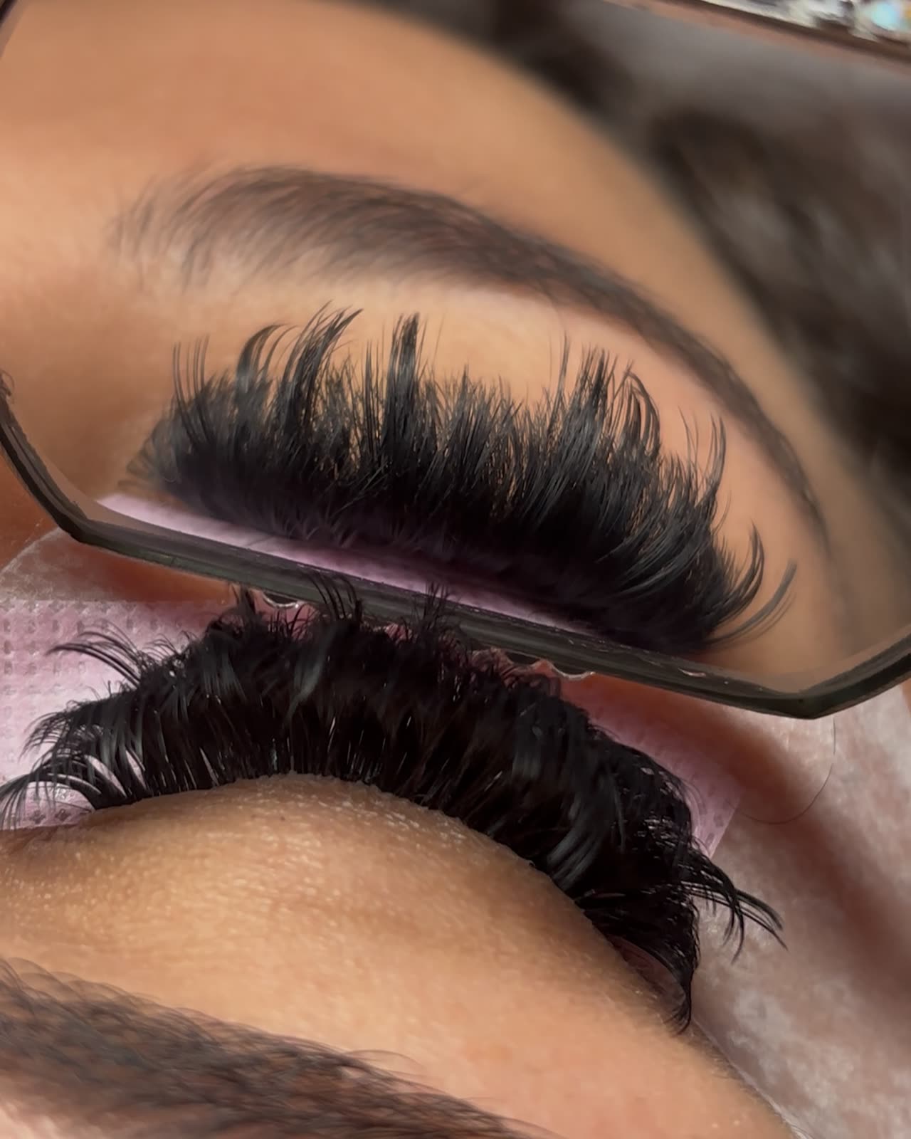 Full volume lash set reflected in a hand mirror